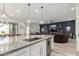 Open-concept kitchen island flows into a living space with dark accent wall and modern decor at 3522 E Penedes Dr, Gilbert, AZ 85298