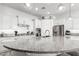 Bright kitchen boasts a large curved island with granite countertops and stainless steel appliances at 3522 E Penedes Dr, Gilbert, AZ 85298