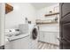 Bright laundry room featuring modern washer and dryer, with floating shelves and cabinets at 3522 E Penedes Dr, Gilbert, AZ 85298