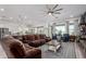 Spacious living room area featuring a large comfortable couch, ceiling fan, and an open floor plan at 3522 E Penedes Dr, Gilbert, AZ 85298