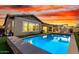Sparkling pool at dusk with landscape lighting, lush turf, and comfortable lounge seating at 3522 E Penedes Dr, Gilbert, AZ 85298