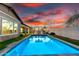 Swimming pool with blue water, surrounded by green turf and inviting lounge chairs at sunset at 3522 E Penedes Dr, Gilbert, AZ 85298