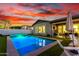Inviting backyard pool with cozy lounge seating, turf and outdoor dining area at sunset at 3522 E Penedes Dr, Gilbert, AZ 85298