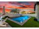 Backyard features a refreshing pool with synthetic grass and a serene atmosphere at sunset at 3522 E Penedes Dr, Gilbert, AZ 85298