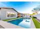Backyard view of the home's swimming pool with green turf and white lounge furniture at 3522 E Penedes Dr, Gilbert, AZ 85298