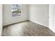 Cozy bedroom with a window view, neutral paint, and wood-look tile flooring at 4171 E Ronald St, Gilbert, AZ 85295