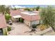 A view of the backyard of a home with a red tile roof, a brick patio, desert landscaping, and outdoor seating at 4436 E Shomi St, Phoenix, AZ 85044