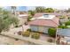 A view of the backyard of a home with a red tile roof, a stone patio, and desert landscaping at 4436 E Shomi St, Phoenix, AZ 85044