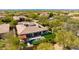 Aerial view showcasing the home's backyard pool, outdoor seating, unique roof design, and lush landscaping at 5414 E Palo Brea Ln, Cave Creek, AZ 85331