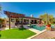 Inviting backyard oasis featuring a pool, outdoor kitchen, pergola, and artificial turf, perfect for entertaining at 5414 E Palo Brea Ln, Cave Creek, AZ 85331