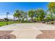 Community basketball court with well-maintained pavement and visible basketball hoop, surrounded by lush green grass and trees at 579 E Mary Ct, Gilbert, AZ 85295