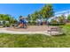 Community playground featuring a slide, swings, and climbing structure for enjoyment in a lush park setting at 579 E Mary Ct, Gilbert, AZ 85295