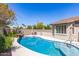 Inviting backyard pool with a rock waterfall feature, surrounded by lush landscaping and a charming patio area at 579 E Mary Ct, Gilbert, AZ 85295