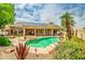 Lush backyard with a sparkling pool, spa, and solar panels, offering an inviting outdoor retreat and entertainment space at 6158 W Donald Dr, Glendale, AZ 85310