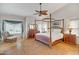 Spacious main bedroom with four-poster bed frame and wood floors at 6158 W Donald Dr, Glendale, AZ 85310
