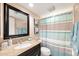 Updated bathroom featuring vanity with granite countertop, framed mirror, toilet, and shower with curtain at 6240 N 16Th St # 45, Phoenix, AZ 85016