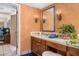 Elegant bathroom with a tiled countertop, decorative mirror, and sconces providing warm lighting at 6301 N Camelback Manor Dr, Paradise Valley, AZ 85253