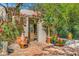 Inviting courtyard entrance with vibrant red flowers, terracotta pots, and a rustic wooden gate at 6301 N Camelback Manor Dr, Paradise Valley, AZ 85253