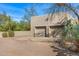 Neutral stucco two-car garage in a desert landscape with mature trees and plants, blending with the surroundings at 6301 N Camelback Manor Dr, Paradise Valley, AZ 85253