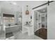 Bright bathroom with vanity, standalone tub, shower, and walk-in closet with sliding barn door at 6340 E Mitchell Dr, Scottsdale, AZ 85251