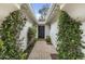 Inviting entryway with green foliage and a brick walkway leading to a classic black door at 6340 E Mitchell Dr, Scottsdale, AZ 85251