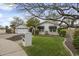 Inviting single-story home with a well-manicured lawn, mature trees, and white exterior at 6340 E Mitchell Dr, Scottsdale, AZ 85251