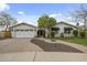 Charming single-story home with a white exterior, inviting landscaping, and a brick driveway at 6340 E Mitchell Dr, Scottsdale, AZ 85251