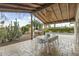Covered patio featuring an outdoor kitchen, dining area, and view of the pool and lush landscaping at 6340 E Mitchell Dr, Scottsdale, AZ 85251