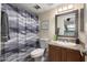Bathroom with granite counter, gray tile shower with gray-and-white curtain, and soft lighting at 7110 E Continental Dr # 1044, Scottsdale, AZ 85257