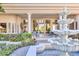 Backyard view featuring a tiered water fountain, outdoor seating, garden, and a large luxury home at 7630 E Vaquero Dr, Scottsdale, AZ 85258