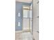 Well-lit bathroom featuring a tiled walk-in shower and white storage cabinets with blue knobs at 7630 E Vaquero Dr, Scottsdale, AZ 85258