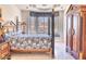 Elegant bedroom featuring a four poster bed, seating area near the bay window, and wooden storage armoire at 7630 E Vaquero Dr, Scottsdale, AZ 85258