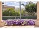 Exterior view showcasing colorful flowers, a tennis court, and lush landscaping at 7630 E Vaquero Dr, Scottsdale, AZ 85258