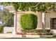 Home exterior showcasing a spiral staircase, manicured shrubs, flower beds, and a partial view of the yard at 7630 E Vaquero Dr, Scottsdale, AZ 85258