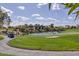 View of a golf course, lake, and community homes under a partly cloudy, bright blue sky at 7630 E Vaquero Dr, Scottsdale, AZ 85258