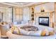 This living room showcases a fireplace, custom built-ins, and a comfortable seating area with an ornate ottoman at 7630 E Vaquero Dr, Scottsdale, AZ 85258