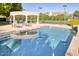 Backyard pool with outdoor seating area and landscaping, along with a tennis court in the background at 7630 E Vaquero Dr, Scottsdale, AZ 85258