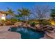 Beautiful backyard with a freeform pool, rock features, and lush landscaping for a private oasis at 8427 E Preserve Way, Scottsdale, AZ 85266