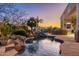 Inviting pool area with rock waterfalls, a cozy outdoor fireplace, and plenty of space for relaxation at 8427 E Preserve Way, Scottsdale, AZ 85266
