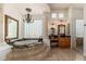 Elegant bathroom features a sunken tub, granite counters, glass block window, chandelier, and dual vanities at 8427 E Preserve Way, Scottsdale, AZ 85266