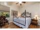 Cozy bedroom features hardwood floors, a wrought iron bed frame, and a comfortable armchair at 8427 E Preserve Way, Scottsdale, AZ 85266
