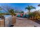 Cozy backyard outdoor fireplace seating area with a built-in grill and manicured landscaping at 8427 E Preserve Way, Scottsdale, AZ 85266