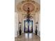 Elegant foyer showcasing a decorative chandelier and iron-wrought doors, complemented by sconces and tiled flooring at 8427 E Preserve Way, Scottsdale, AZ 85266