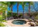 Secluded hot tub surrounded by desert landscaping, mature palms, and rock features at 8427 E Preserve Way, Scottsdale, AZ 85266