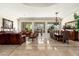 Open-concept living room and dining area with tile floors, large windows, and elegant chandelier, exuding sophistication at 8427 E Preserve Way, Scottsdale, AZ 85266