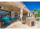 Outdoor living space features a built-in stainless steel grill, flagstone patio, and comfortable turquoise seating at 8427 E Preserve Way, Scottsdale, AZ 85266