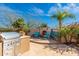 Outdoor entertaining space with stainless grill, seating area with fireplace, and mature landscaping at 8427 E Preserve Way, Scottsdale, AZ 85266