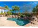 Beautiful pool features stone accents, mature palms and landscaping, and clear blue water at 8427 E Preserve Way, Scottsdale, AZ 85266