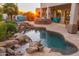 This backyard boasts a stunning pool with rock waterfall features and ample seating for relaxation at 8427 E Preserve Way, Scottsdale, AZ 85266