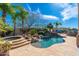 Relaxing pool and spa surrounded by mature palms, a rock waterfall, and desert landscaping at 8427 E Preserve Way, Scottsdale, AZ 85266
